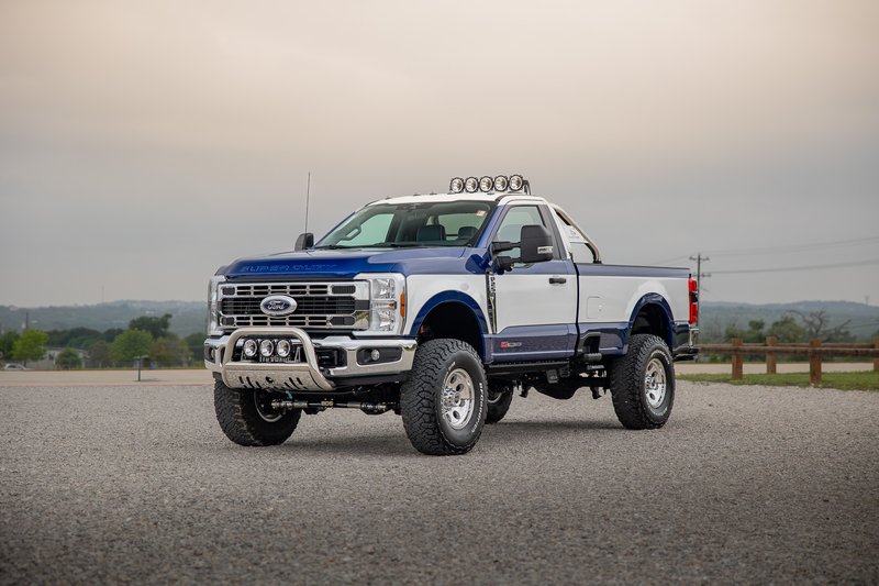 Blue and white 2026 Ford F-250 Super Duty with custom livery and rims.