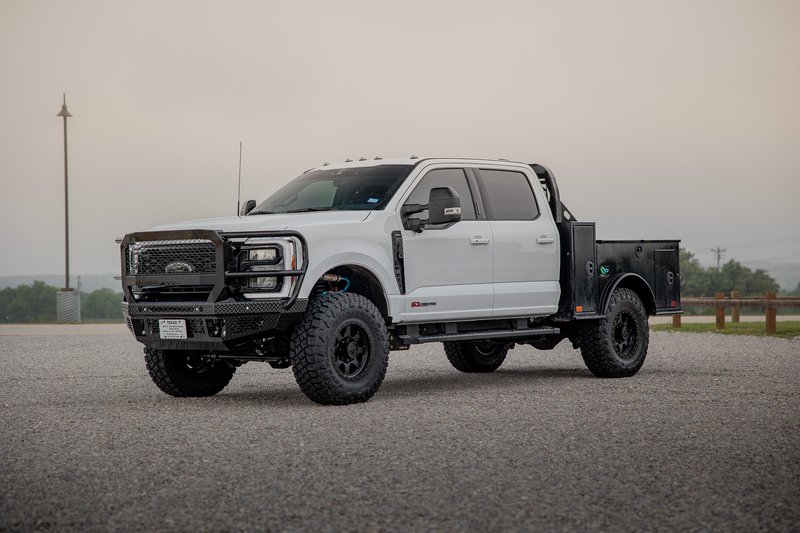 2026 Ford F-350 SRW flatbed truck in white with black rims and custom bumpers.