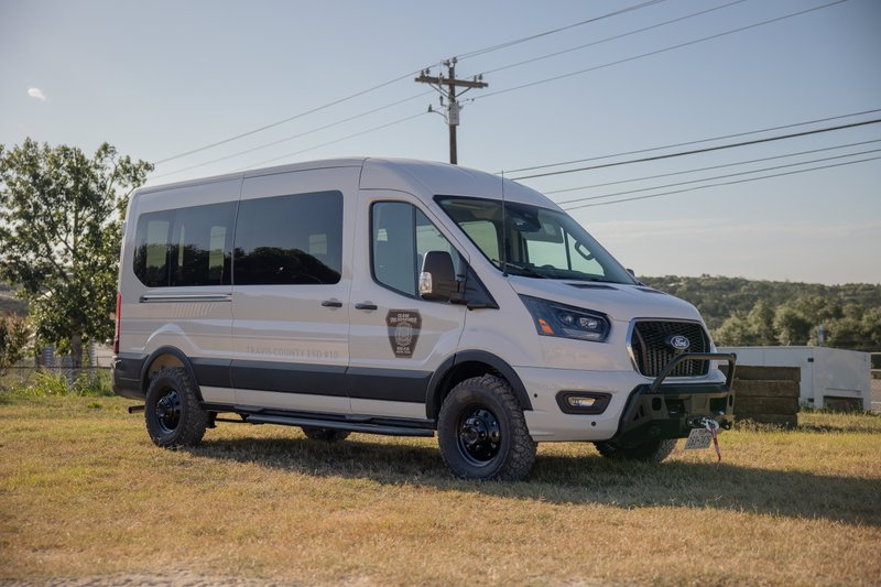 Ford Transit 4x4 van in beige, with heavy-duty bumper, winch, and off-road rims.