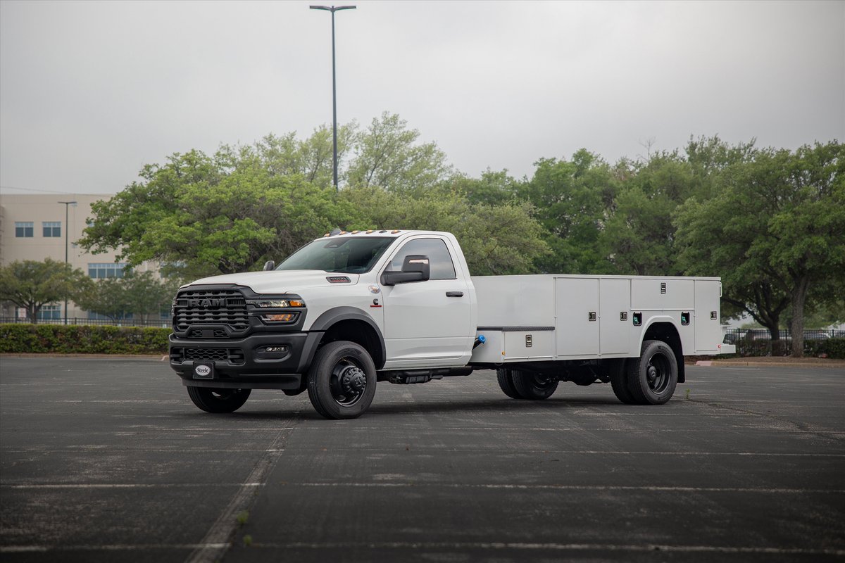 White Ram 5500 service truck with utility body and black rims parked outdoors.