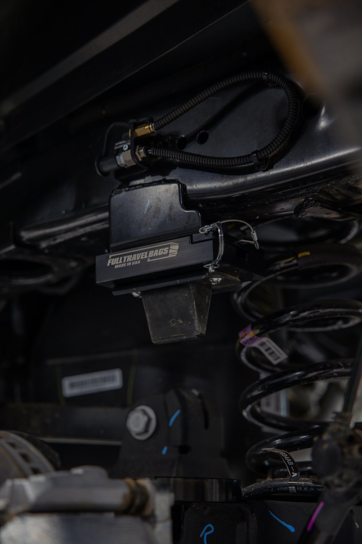 Black SUV undercarriage with Full Travel Bags air spring system installed.