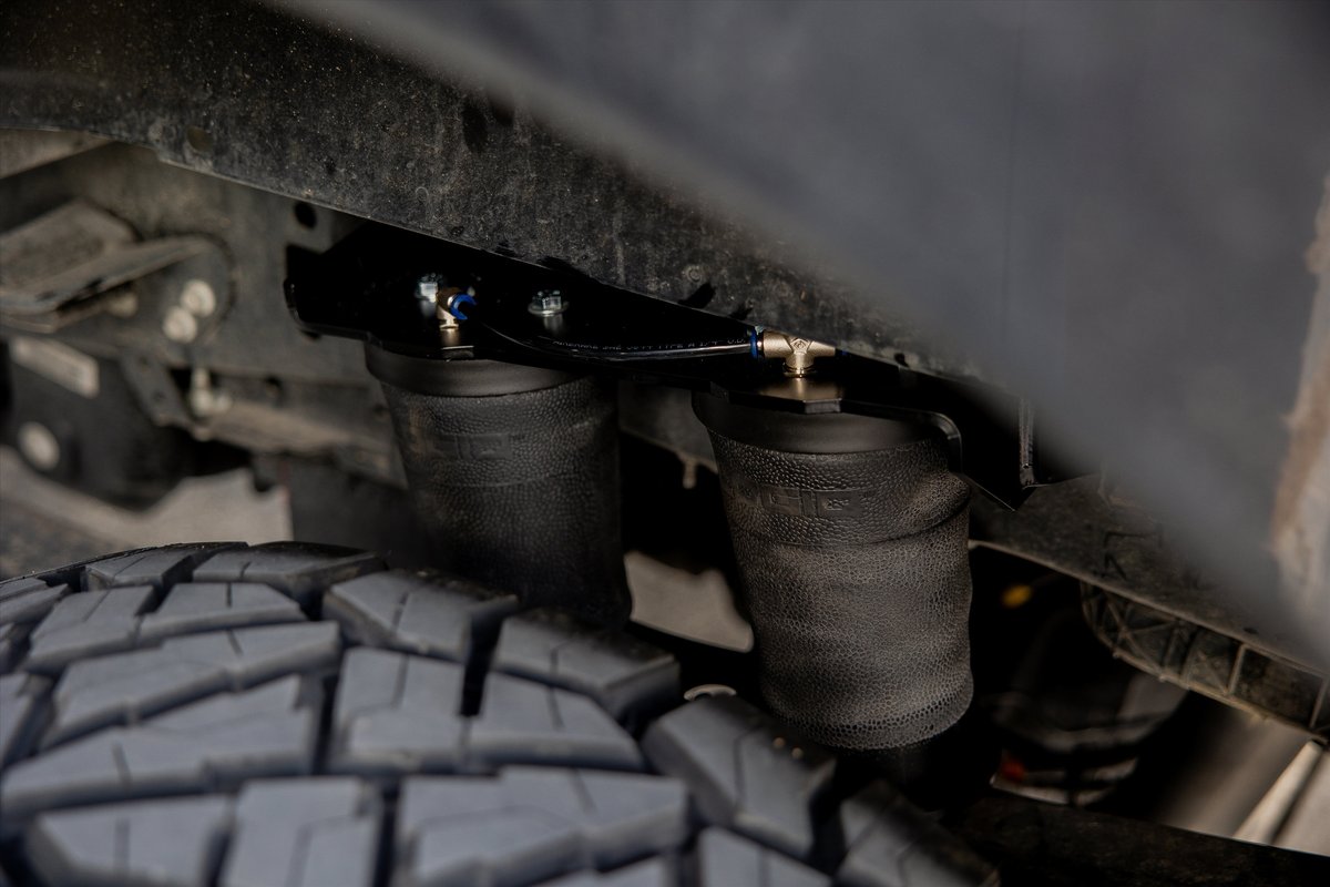 Close-up of truck's rear air suspension bags and tire treads.